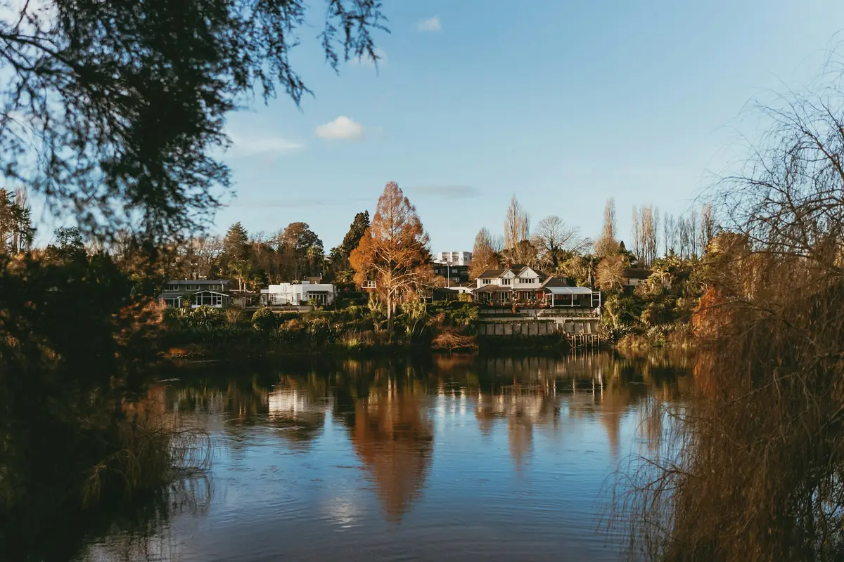 Waikato River lined with trees and houses in Hamilton