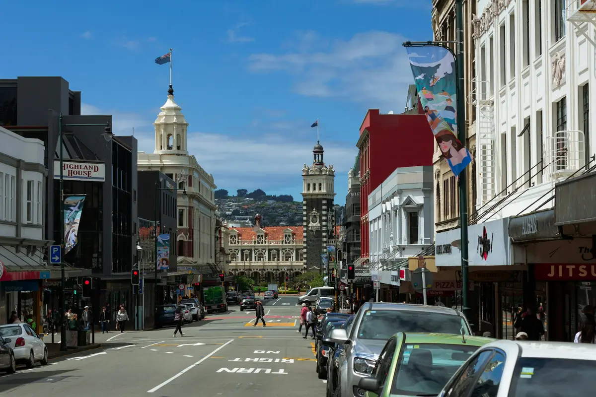 Tall buildings and parked cars on a Dunedin city street