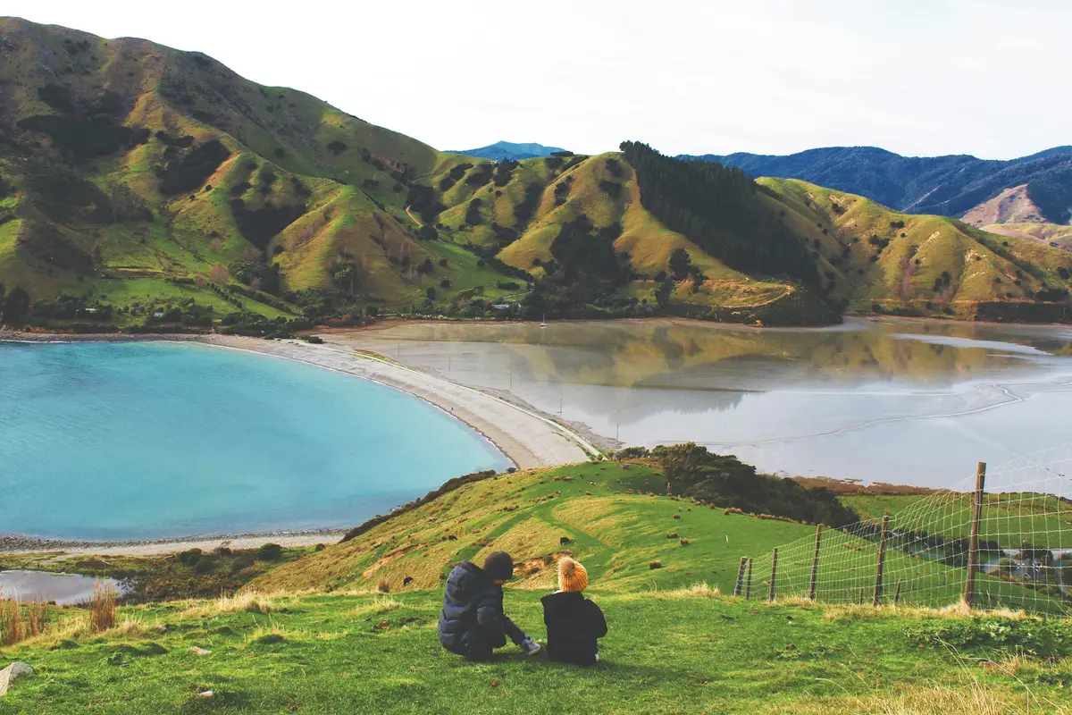 Couple relaxing on the grass at Cable Bay near Nelson