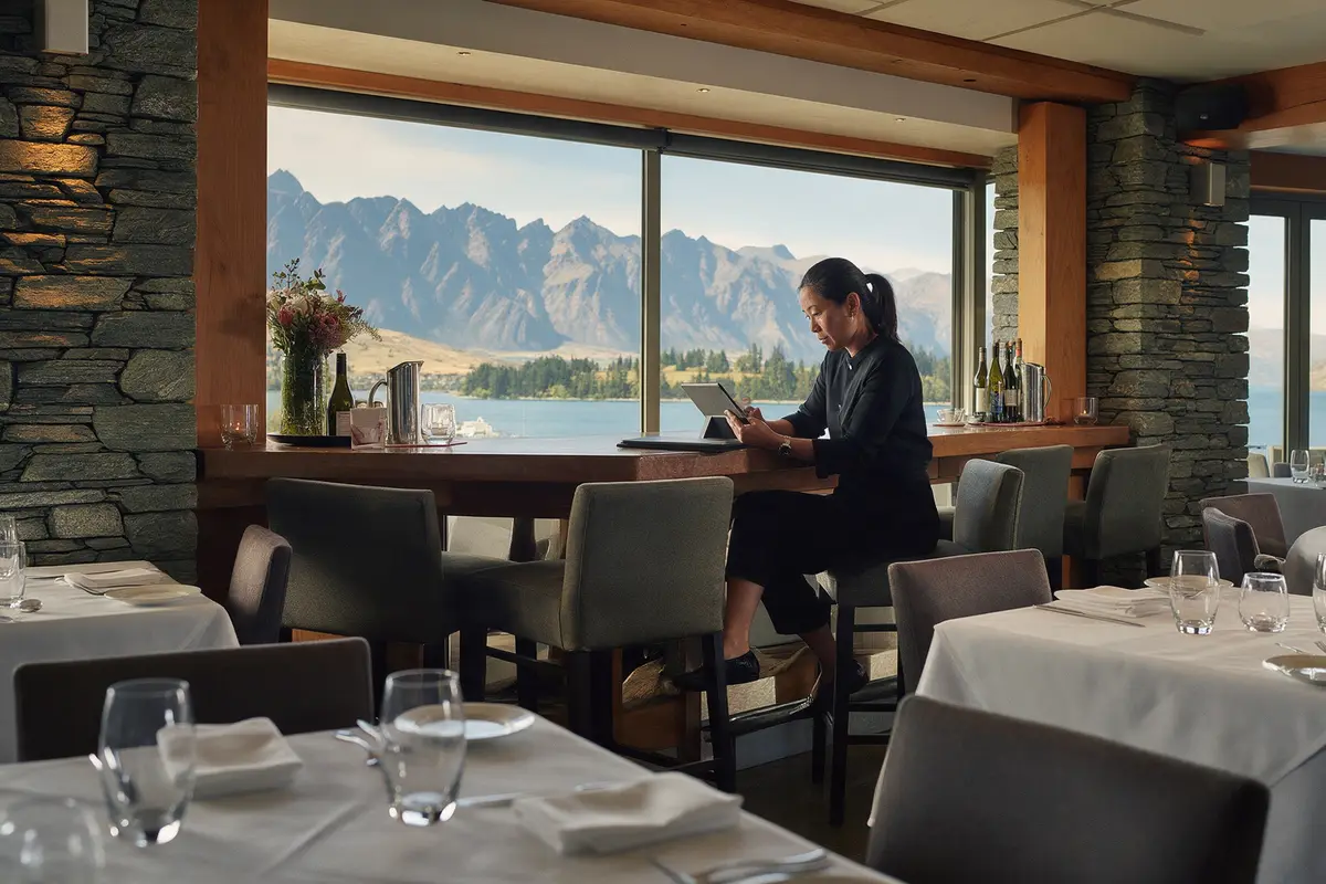 Restaurant owner reviewing accounts during a quiet afternoon in a Queenstown restaurant